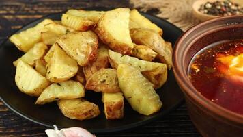 gebakken aardappelen in een zwart bord. een schotel in een restaurant. video