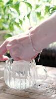 Opening a drip pack with coffee in a transparent mug, against a green background, close-up video