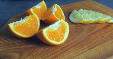 Four slices of juicy orange lie on a wooden board video
