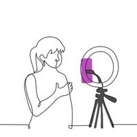Woman broadcasts while standing in front of a phone camera mounted on a ring lamp - one line art . concept live stream of a female blogger vector