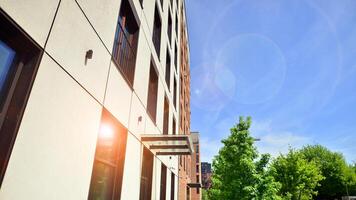 Modern residential building with new apartments in a green residential area. Eco architecture. Green tree and new apartment building. The harmony of nature and modernity. photo