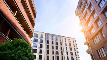 Modern residential building with new apartments in a green residential area. Eco architecture. Green tree and new apartment building. The harmony of nature and modernity. photo