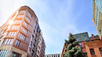 Modern residential building with new apartments in a green residential area. Eco architecture. Green tree and new apartment building. The harmony of nature and modernity. photo