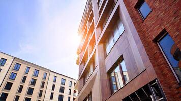 Contemporary residential building exterior in the daylight. Modern apartment buildings on a sunny day with a blue sky. Facade of a modern apartment building photo