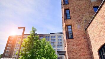 Modern residential building with new apartments in a green residential area. Eco architecture. Green tree and new apartment building. The harmony of nature and modernity. photo