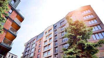 Modern residential building with new apartments in a green residential area. Eco architecture. Green tree and new apartment building. The harmony of nature and modernity. photo