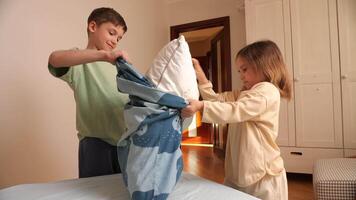 A boy and a little girl help each other make the bed linen video