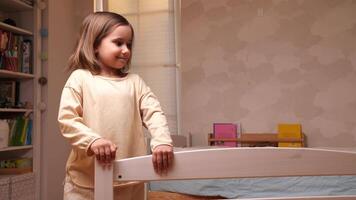 little girl helps to assemble a children's bed, holds a bed part video
