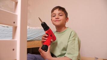 portret van een jongen met een rood elektrisch schroevendraaier, gereedschap video