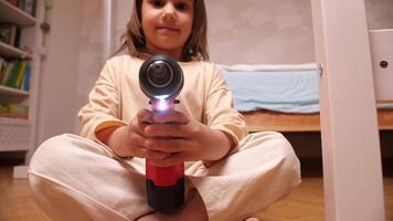 close-up of a little girl with a red power electric screwdriver turned on video