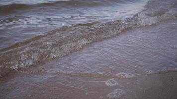 visie van golven raken de kustlijn van een meer 4k video
