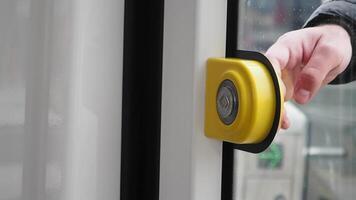 finger presses button to open doors in subway car. video