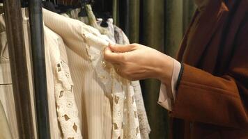 vrouw kiezen kleren in winkel. video