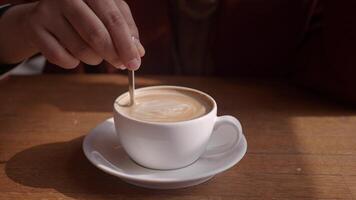 mano de persona revolviendo café con cuchara. video