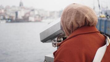 mujer utilizando funciona con monedas prismáticos para mirando fuera ciudad , video