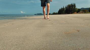 4k antal fot, fötter av man rör på sig långsamt promenad barfota på de strand i morgon. manlig turist under sommar semester i chao lao strand, Chanthaburi, thailand video