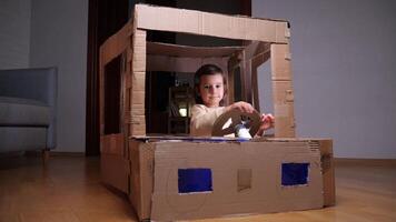 girl playing at home with a car made of cardboard video