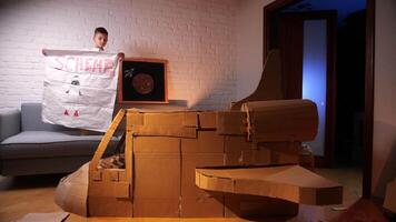 A boy builds a spaceship out of cardboard. The boy dreams of flying into space. video