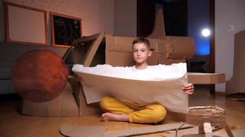 jongen dromen van vliegend naar Mars en in ruimte. ruimteschip uit van karton video