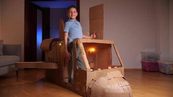 garçon rêves de en volant dans espace. garçon construit une vaisseau spatial en dehors de papier carton video