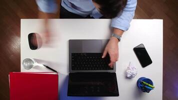 superiore Visualizza tempo periodo un' uomo nel un' camicia lavori con documenti e su un' computer video