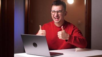 Like. Happy young programmer freelancer man with glasses working on laptop video