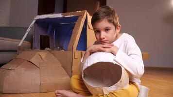 Porträt von ein Junge mit ein Astronaut Helm Nächster zu ein Spielzeug Raumschiff video