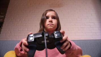 poco ragazza gode giocando Giochi su il consolle con un' gamepad video