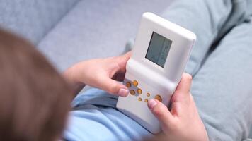 top view of a boy playing old games on a vintage handheld console video