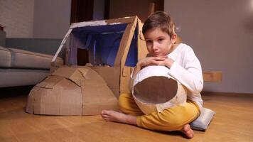 portrait of a boy with a homemade astronaut helmet and a spaceship video