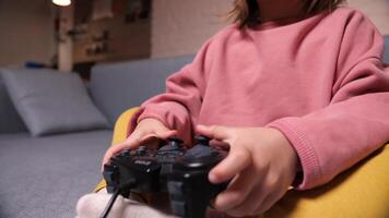 poco ragazza giocando un' gioco su un' console, utilizzando un' controllore. video