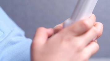 close-up A boy presses bright yellow buttons on a console game in a white case video