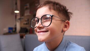 pojke med glasögon, spelar en spel med en kontroller, Kolla på en film video