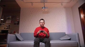 jugador es sentado en un sofá, jugando y victorioso en juegos en consola video