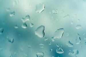 Water drops on glass against blue sky, rainy season concept. Window view background screensaver photo