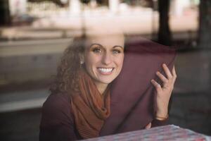 Joyful Woman Holding Fabric Behind Storefront Glass photo