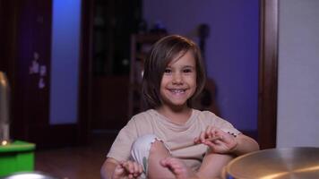 retrato do uma pequeno menina com baquetas, menina tocar bateria em panelas video