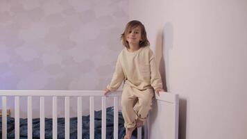 retrato do uma pequeno menina sentado em a cama dentro pijamas video