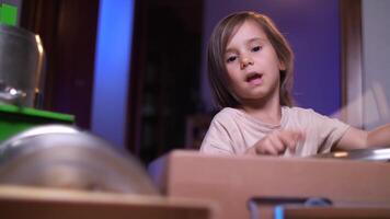 little girl drummer hits a pan with sticks, the girl makes noise video