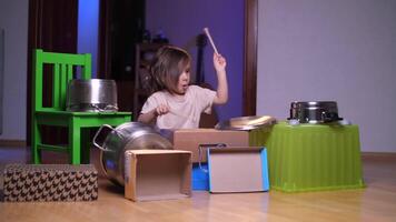 home drum kit, little girl drummer hits a pan with sticks, the girl makes noise video