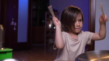 een kind maakt lawaai Bij huis, drums Aan potten en dozen met eetstokjes video