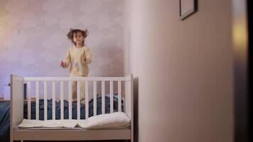 weinig meisje jumping Aan de bed, meisje niet willen naar slaap, ongehoorzaam kind video