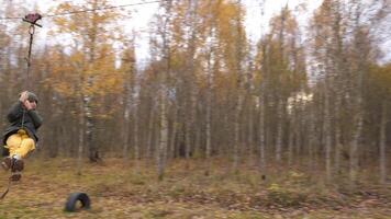 A boy's unsafe descent on a zip line. a boy rides a zip line in the fall video