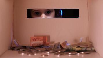 Visualizza a partire dal dentro il porcellino banca, il ragazza mette i soldi in il porcellino banca video