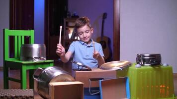 chico obras de teatro en su hogar tambor equipo, chico golpes ollas y cajas con tambores video