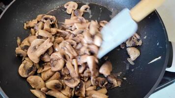 Sliced mushrooms being sauteed in a non stick frying pan, ideal for vegetarian recipes and healthy eating concept video