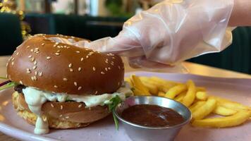 Drücken Sie Finger auf das Burger Essen ein Burger von Rindfleisch Steak Hackfleisch, Soße, Brötchen, karamellisiert Zwiebeln, Käse, Tomate, und Grüner Salat. video