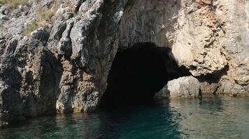 grot stenen water boot tour in de buurt corfu eiland attracties diep schoon Doorzichtig water bergen natuurlijk voorjaar voorbijgaan boot mensen toeristen en reizigers video