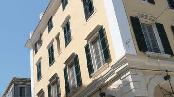 eng Straßen hoch Gelb Gebäude auf das Insel von Korfu Touristen Gehen um das Stadt Magnete Verkauf Leben ist im voll schwingen im ein Tourist Stadt Himmel hoch Gebäude Griechenland video