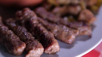 grillé lula kebab sur brochette sur gril, barbecue, patates cales, sucré poivre, chaud jeter le fer grille. proche en haut. video